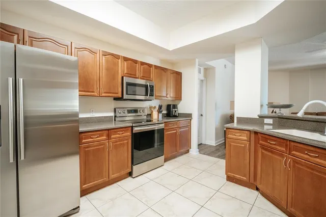 a kitchen with kitchen island granite countertop a refrigerator stove top oven and sink