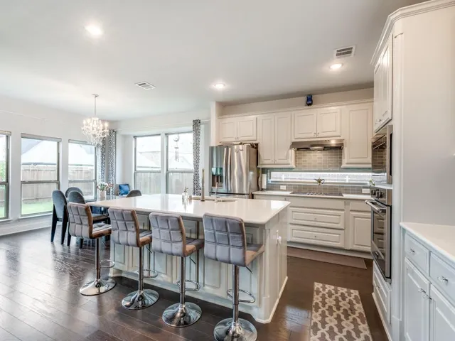 a large kitchen with a table and chairs