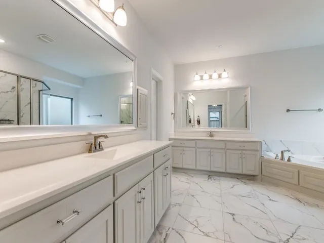 a bathroom with a granite countertop sink a toilet a mirror and bathtub