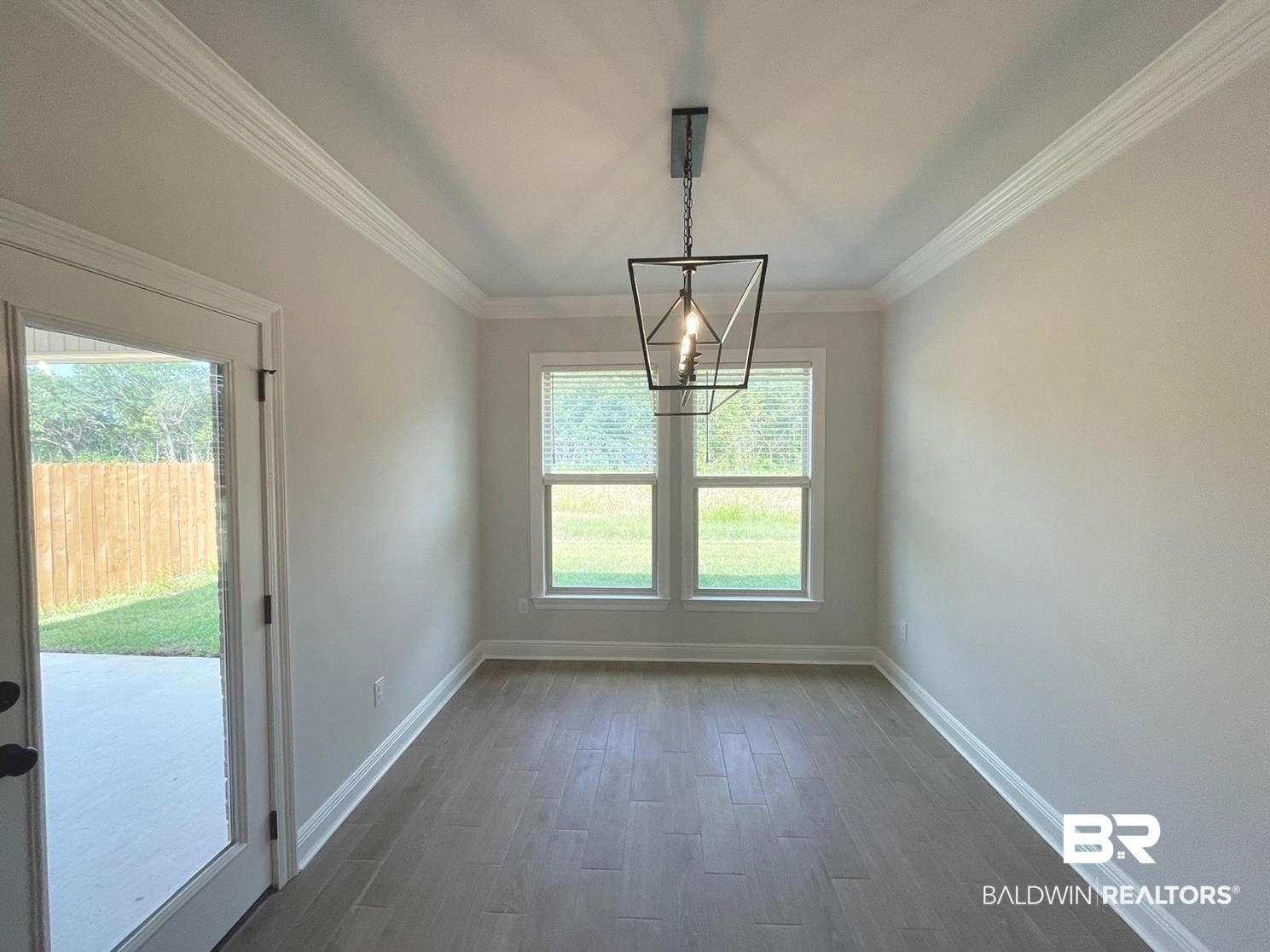 1424 Fenton Circle Foley, AL 36535 - Photo 8 of 20 Empty room with crown molding, an inviting chandelier, and dark hardwood / wood-style flooring