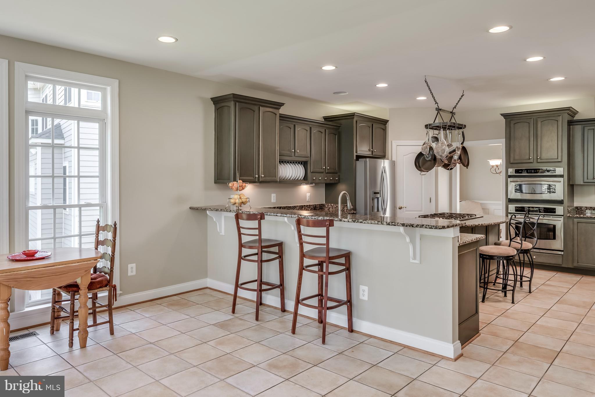 42724 Ridgeway Drive Broadlands, VA 20148 - Photo 7 of 30 a kitchen with kitchen island granite countertop counter space dining table and a sink