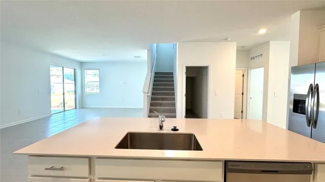 a kitchen with a sink and a large mirror