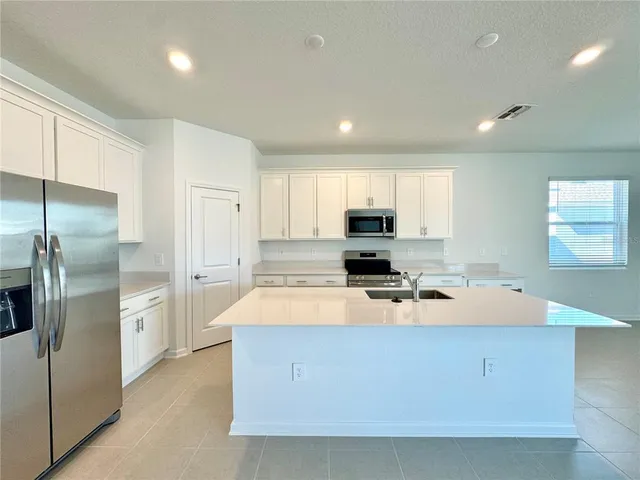 a kitchen with stainless steel appliances a refrigerator sink and stove