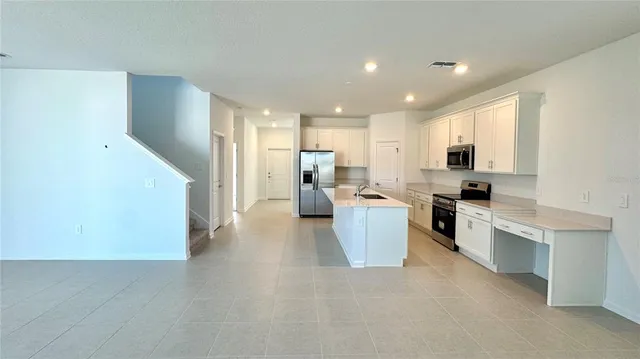 a kitchen with white cabinets and stainless steel appliances