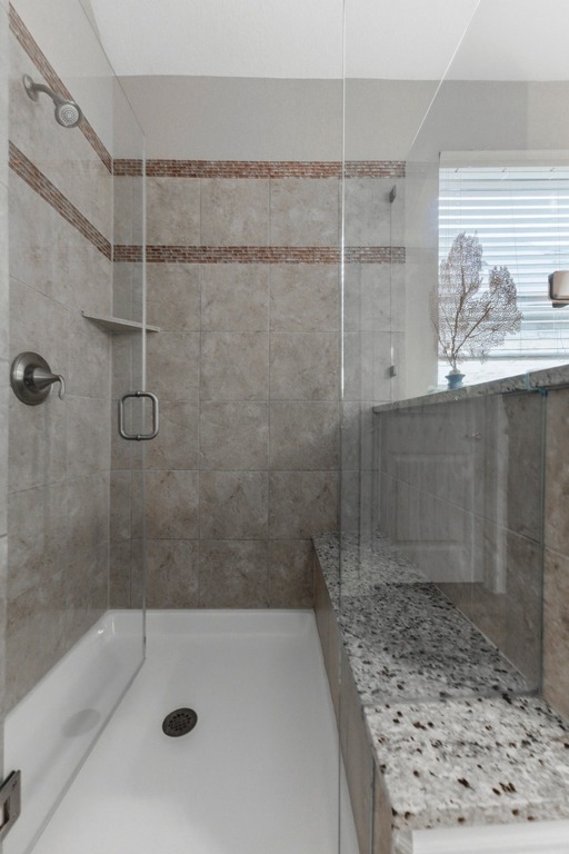 5425 Cherokee Draw Road Austin, TX 78738 - Photo 24 of 40 A well-appointed shower space features granite counters and tile walls, combining luxury and function.