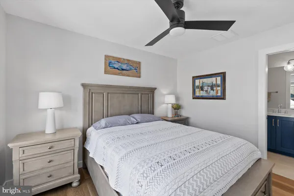 a bedroom with a bed and a lamp on dresser