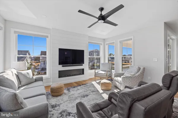 a living room with furniture a flat screen tv and a large window