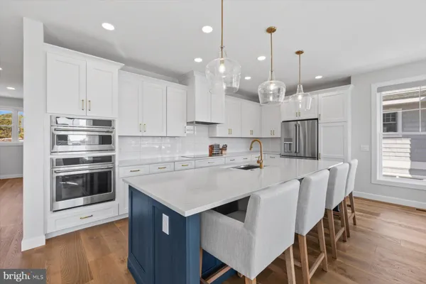 a kitchen with kitchen island a stove a table and chairs