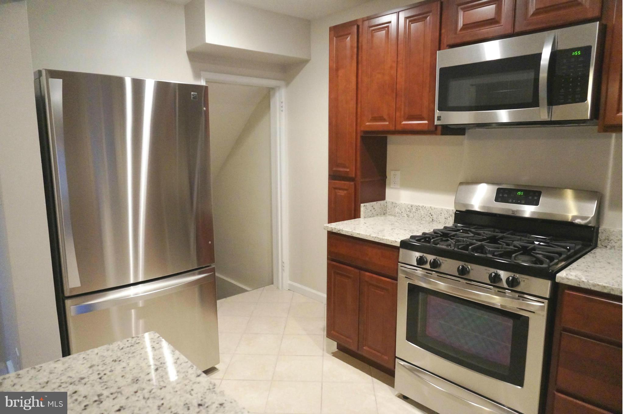 2011 Ormand Road Baltimore, MD 21222 - Photo 5 of 28 a kitchen with stainless steel appliances kitchen island granite countertop a refrigerator stove and microwave