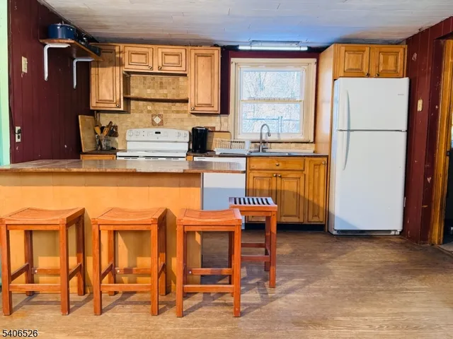 a dining area with stainless steel appliances granite countertop a refrigerator and a stove top oven