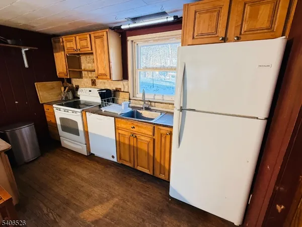 a kitchen with a sink a refrigerator a window and a stove