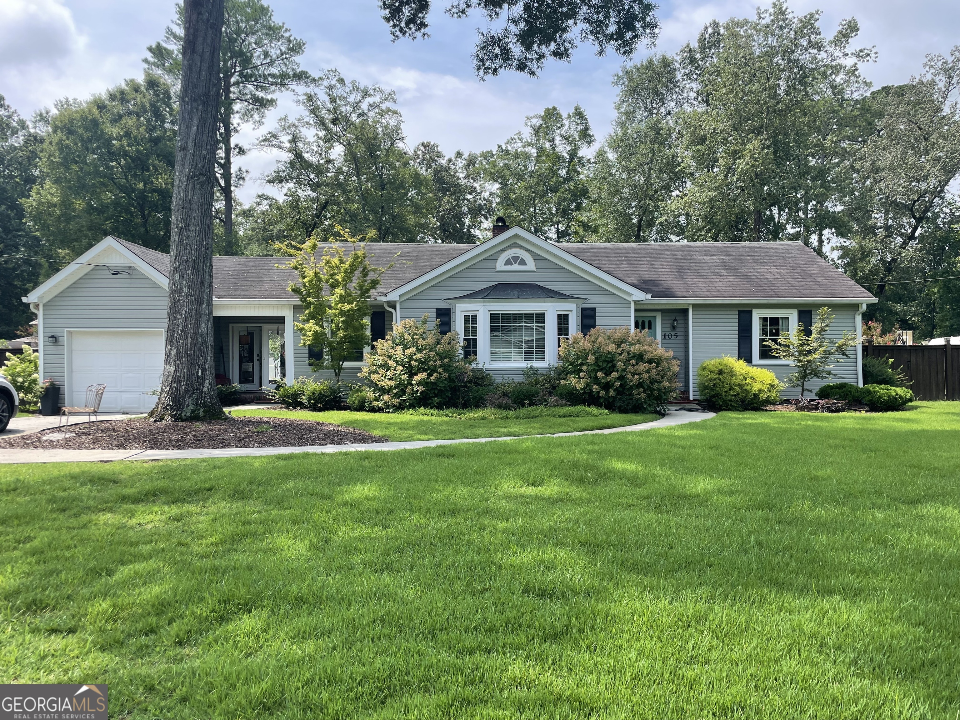 a front view of a house with a yard and trees