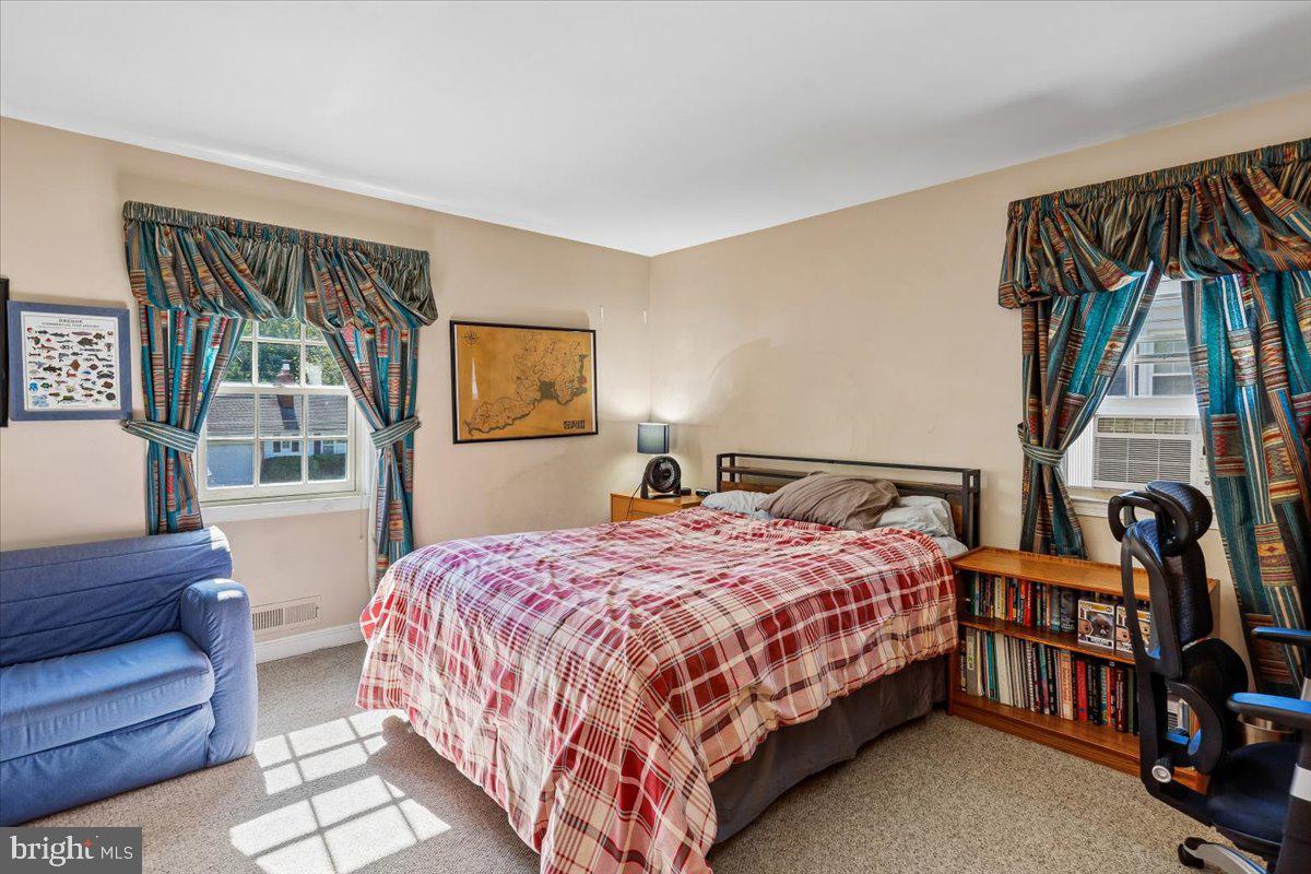 7918 Ruxway Road Towson, MD 21204 - Photo 25 of 36 a bedroom with a bed a bookshelf and a window