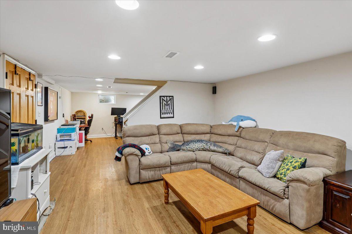 7918 Ruxway Road Towson, MD 21204 - Photo 31 of 36 a living room with furniture a wooden floor and a flat screen tv