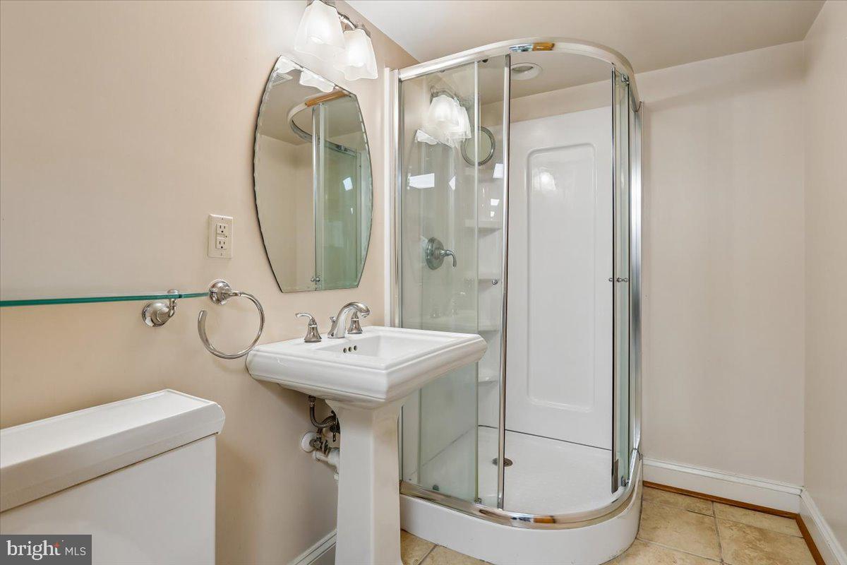 7918 Ruxway Road Towson, MD 21204 - Photo 33 of 36 a bathroom with a sink a mirror a glass door a shower and a mirror
