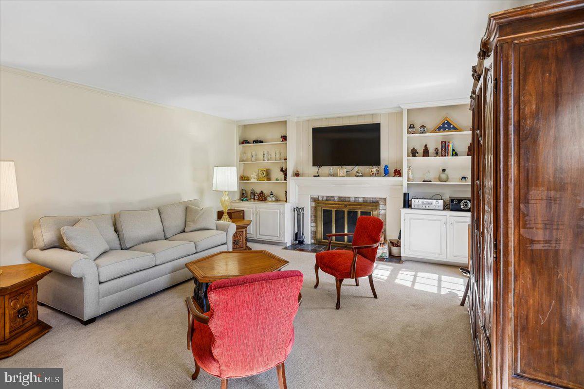7918 Ruxway Road Towson, MD 21204 - Photo 8 of 36 a living room with furniture a flat screen tv and a fireplace