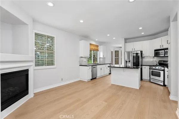 a kitchen with stainless steel appliances kitchen island granite countertop a stove and a refrigerator