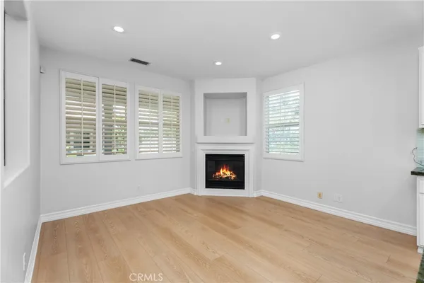 a view of an empty room with window and fire place