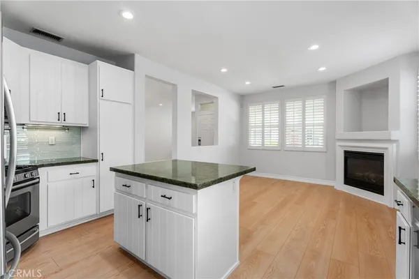 a kitchen with granite countertop cabinets stainless steel appliances and a window