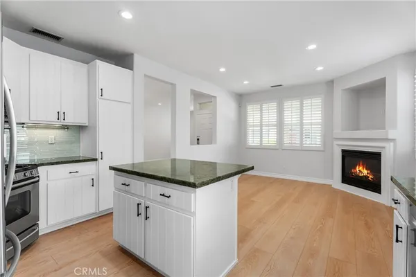 a kitchen with granite countertop a stove sink and cabinets