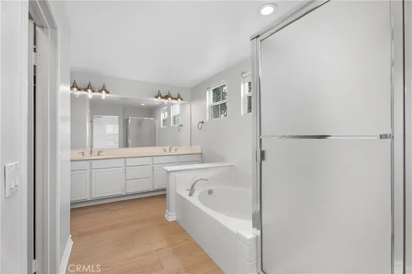 a large white bathroom with a bathtub and a sink