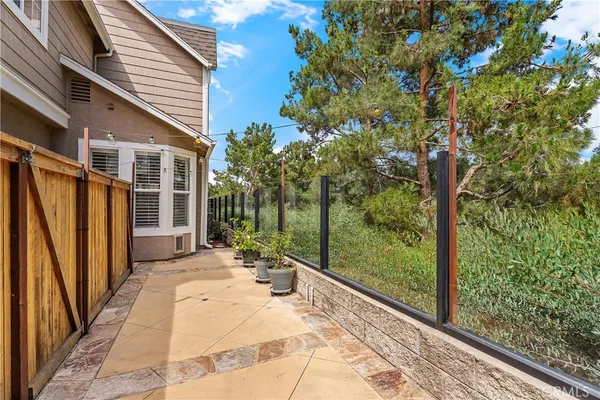 a view of backyard with large trees and wooden fence