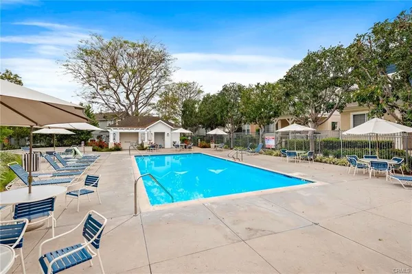 a view of a swimming pool with lawn chairs under an umbrella