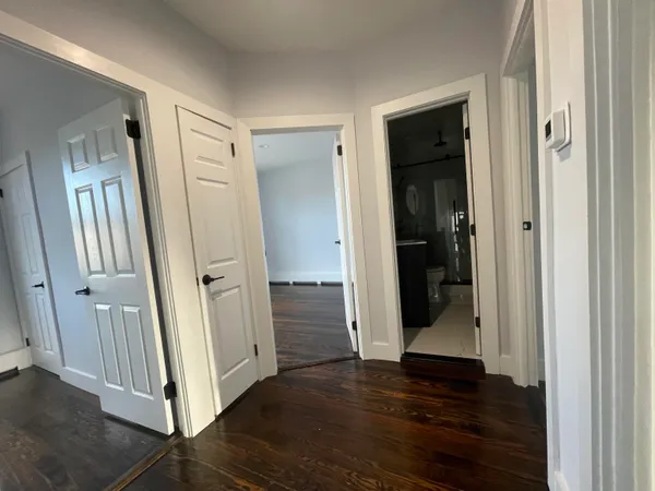 an entryway door and hallway with wooden floor