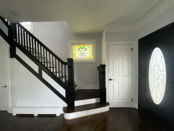 a view of a hallway with wooden floor and entryway
