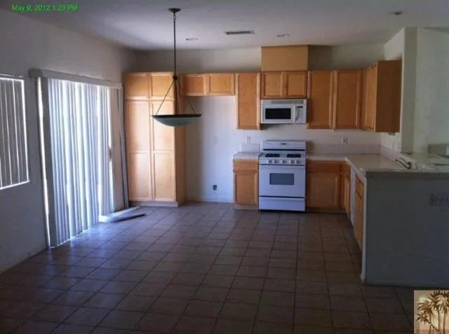 a kitchen with stainless steel appliances granite countertop a stove a sink and a refrigerator with wooden floor