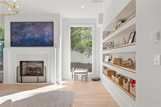 a kitchen with kitchen island a dining table chairs sink and white cabinets