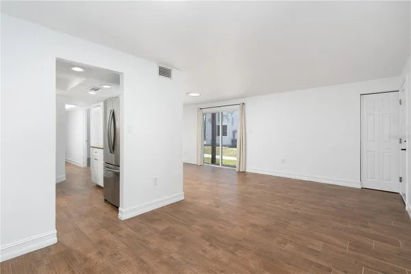 a view of kitchen with stainless steel appliances kitchen island a refrigerator a stove a microwave and white cabinets