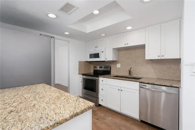 a kitchen with stainless steel appliances granite countertop a refrigerator and a sink
