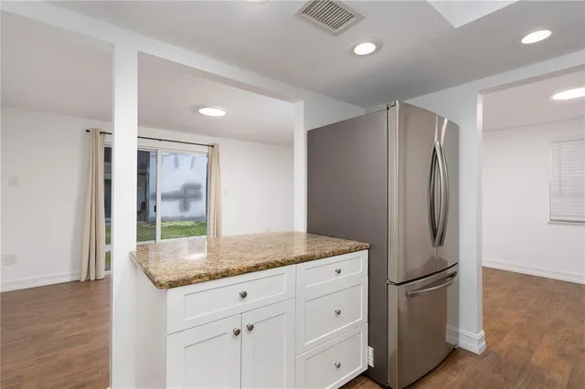 a kitchen with stainless steel appliances granite countertop a sink and a refrigerator