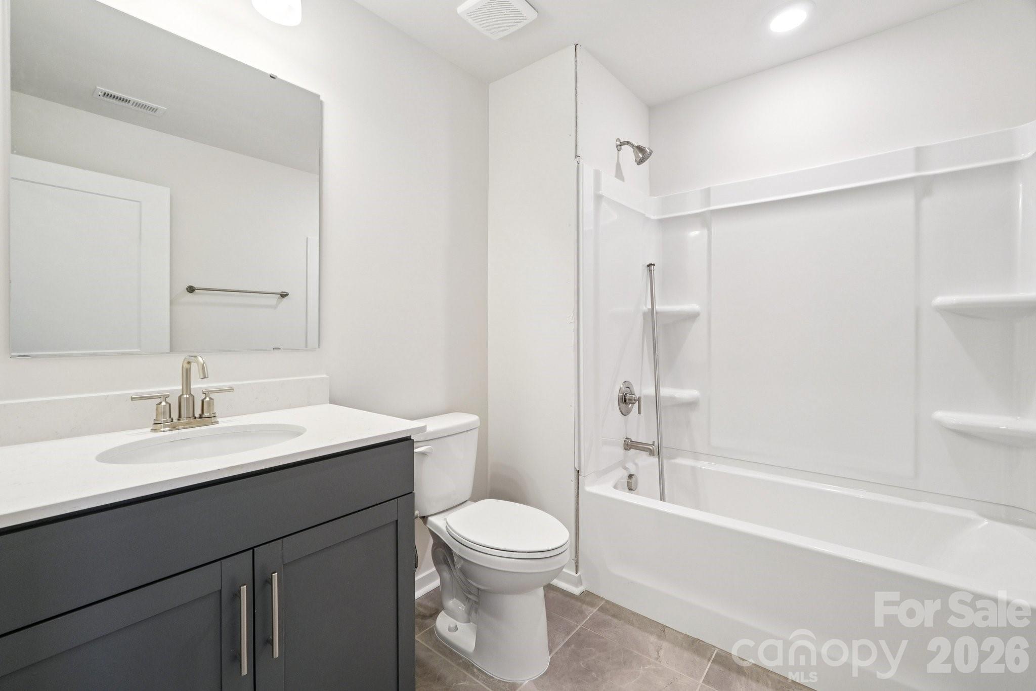 7685 Bainbridge Road Sherrills Ford, NC 28673 - Photo 30 of 33 a bathroom with a toilet a sink a mirror a bathtub and vanity