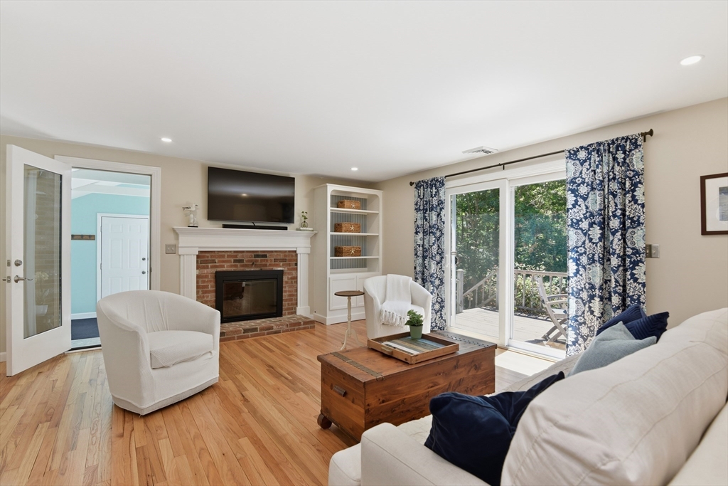 8 Emerald Way Sandwich, MA 02644 - Photo 12 of 36 a living room with furniture a fireplace and a floor to ceiling window