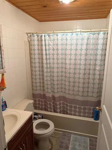 a bathroom with a granite countertop bathtub sink and toilet