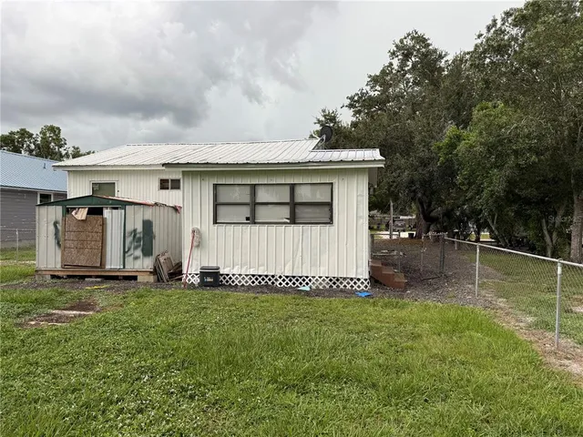 a view of a house with backyard and a tree