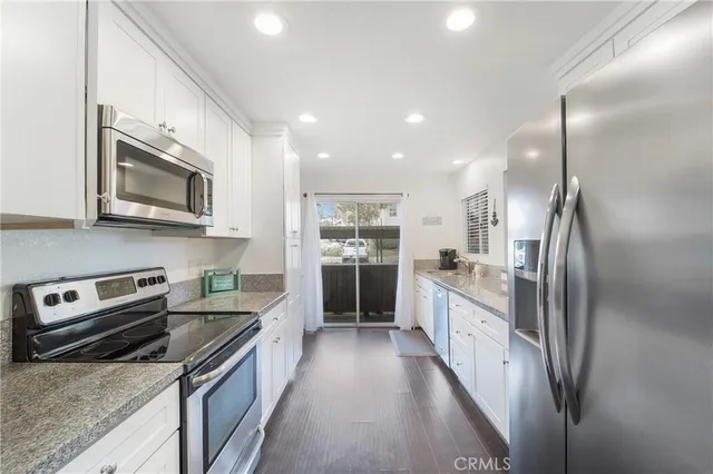 a large kitchen with stainless steel appliances granite countertop a stove a sink and a refrigerator