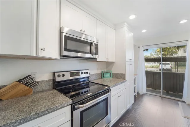 a kitchen with stainless steel appliances granite countertop a stove and a microwave