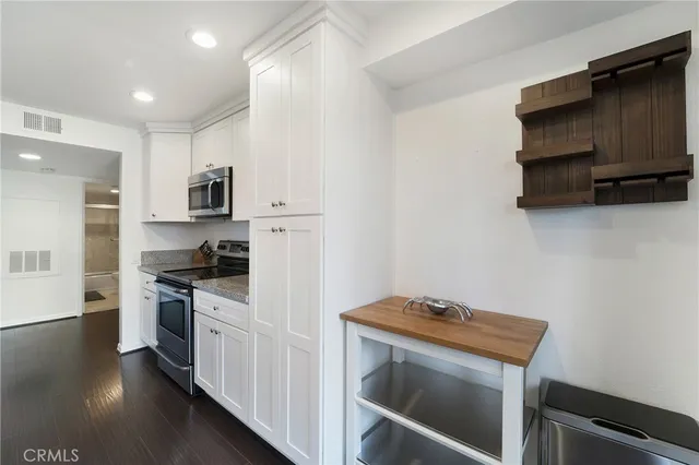 a kitchen with stainless steel appliances a stove microwave and sink