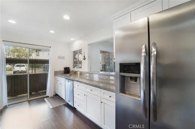 a kitchen with stainless steel appliances granite countertop a refrigerator and a sink