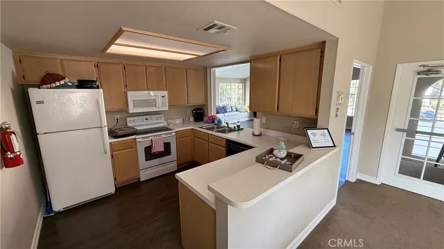 a kitchen with a sink a refrigerator a stove a microwave and cabinets