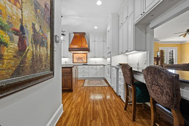 a view of a kitchen with kitchen island wooden floor and electronic appliances