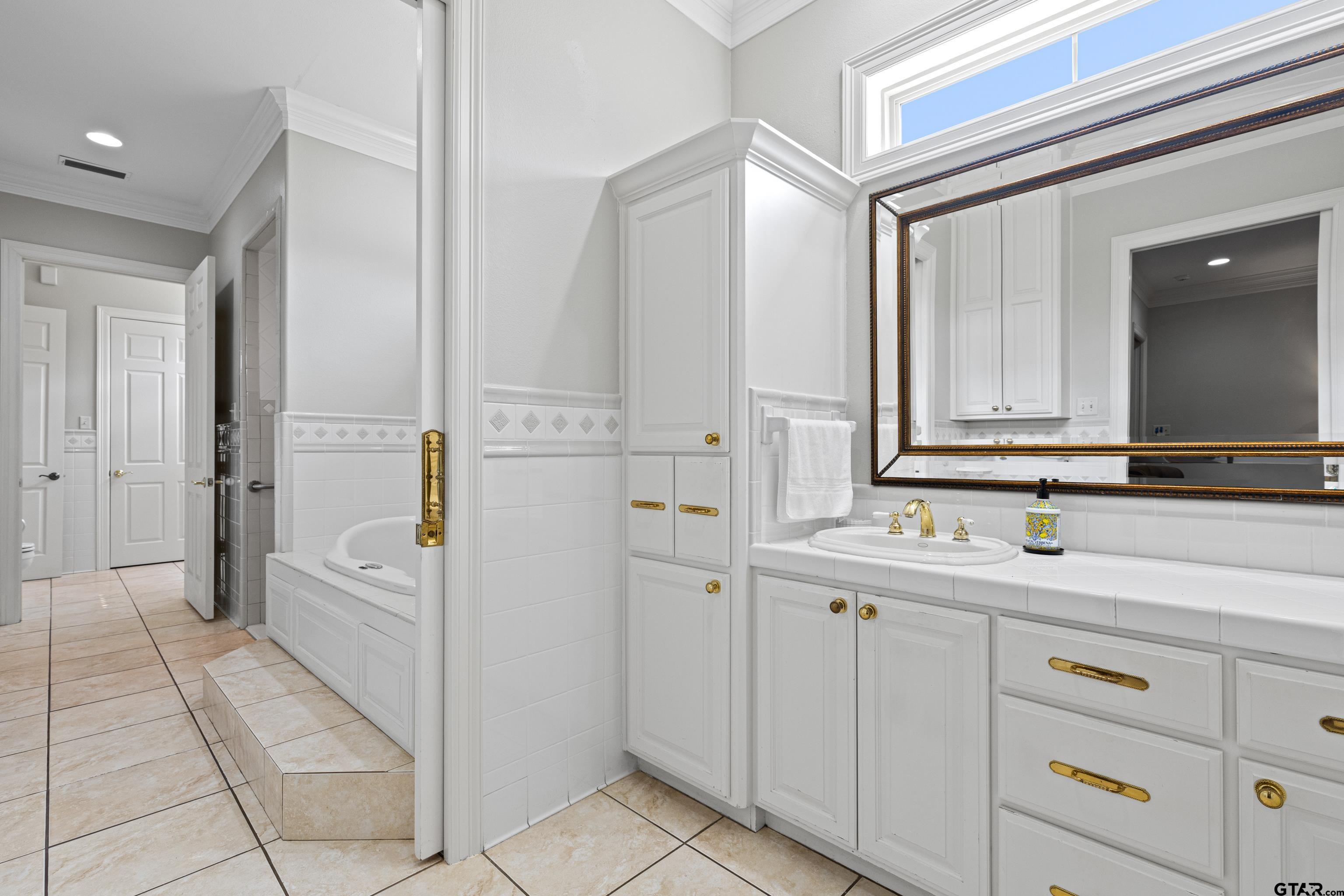 1360 East Main Street Henderson, TX 75652 - Photo 23 of 48 a spacious bathroom with a double vanity sink a mirror and a bathtub
