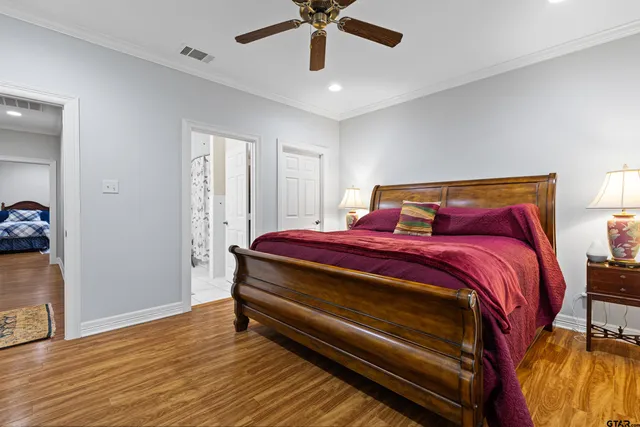 a bedroom with a bed and a lamp on the dresser