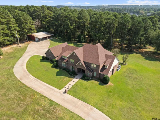an aerial view of a house with a yard basket ball court and outdoor seating