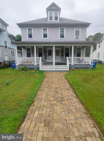 a front view of a brick building with a garden