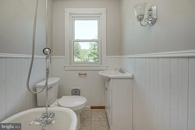 a bathroom with a toilet a sink and mirror