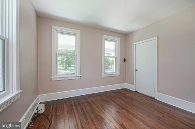 a view of a room with wooden floor and windows